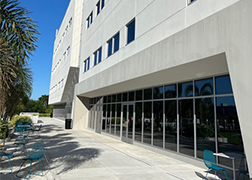A photo of the Ponce Health Sciences University showing a three story beige concrete building.